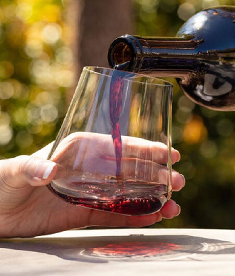 Red wine being poured into a DrinkArt Stemless Universal Glass