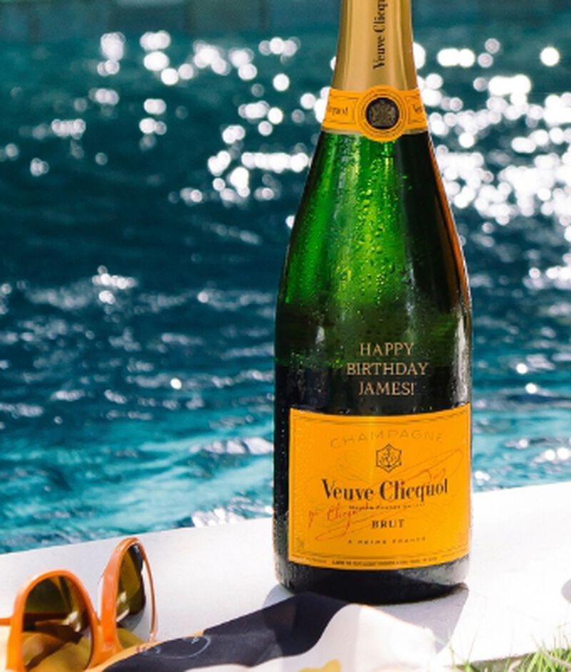 A bottle of veuve cliquot engraved with "Happy Birthday James!"