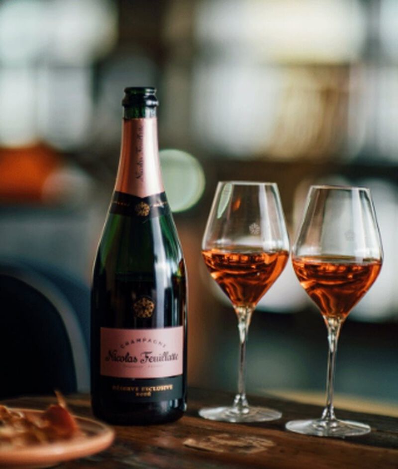 Bottle of Nicolas Feuillatte Réserve Exclusive Rosé Champagne Brut Rosé with two filled champagne flutes