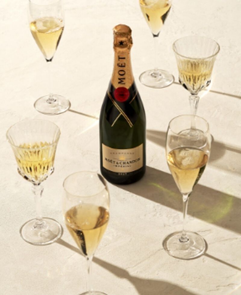 A bottle of Moët & Chandon Imperial Brut surrounded by champagne flutes
