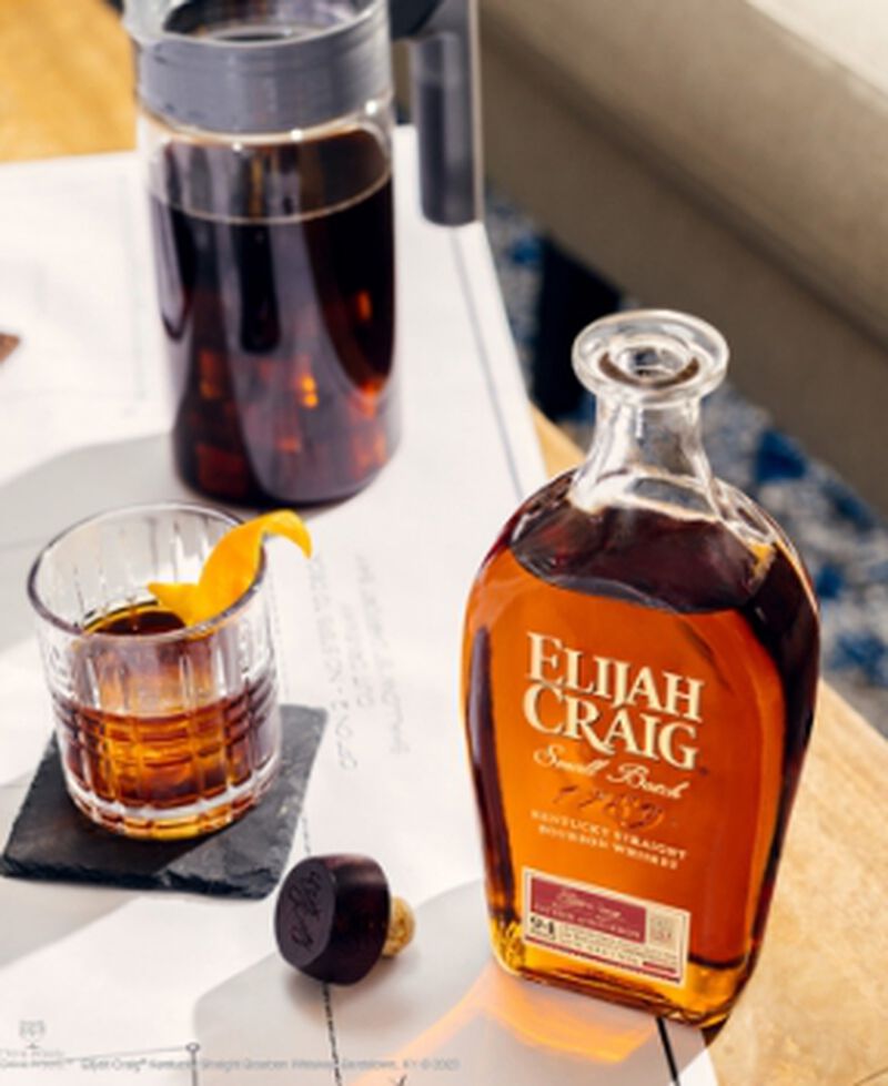 A bottle of Elijah Craig Small Batch with a cocktail