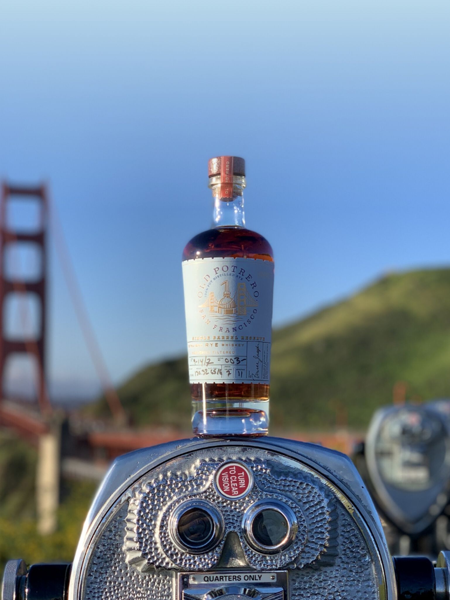 A bottle of Old Potrero Single Barrel Straight Rye Whiskey S1B45 in front of the Golden Gate Bridge